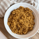 Homemade Brown Sugar in a white bowl with a brown and white striped towel around it