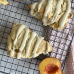 Sourdough Peaches and Cream Scones with halved peached on a wire wrack with pink towel